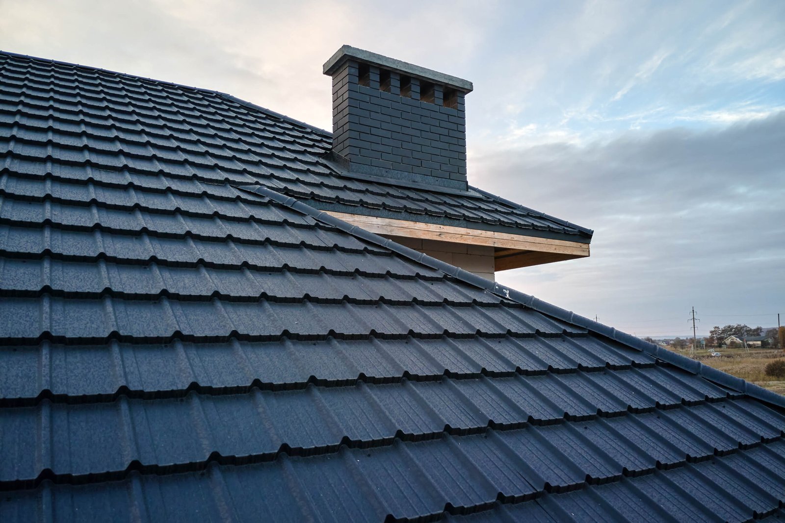 Closeup of house roof top covered with metallic shingles.Tiled covering of building
